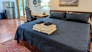 A bedroom with a bed, a desk, a chair, a refrigerator, and a window. - Lake Days Getaway - Lakeside Family Escape Near Hillsborough (Hillsborough)