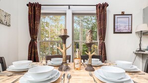 A dining table set with white plates, bowls, and cutlery, flanked by decorative tree-shaped candle holders and a bottle of champagne. - 🐻 Beautiful Overlooking Shoreline 2bdr Chalet 18396 (Arcadia)