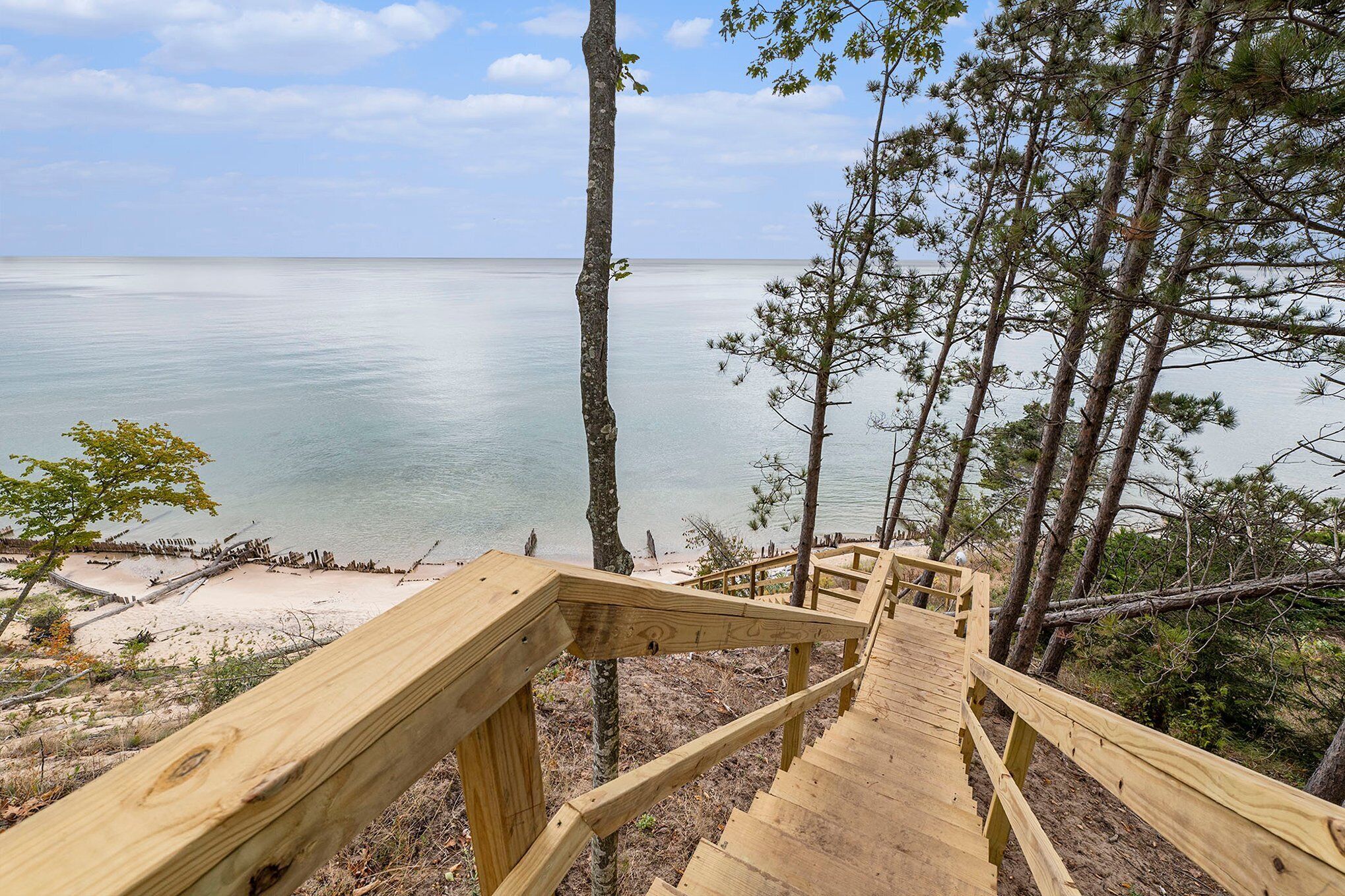 Una escalera de madera que lleva a una playa con vistas al mar.
