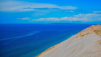 A coastal landscape with a clear view of the sea and a distant shoreline.