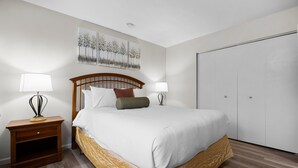 A bedroom with a bed, nightstands, a wardrobe, and a painting on the wall. - Newly Updated Lakeview Golf Retreat 1bdr Condo Resort 5057 (Williamsburg)
