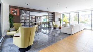 A spacious living area with a modern design, featuring a yellow sofa, a white sofa, and a dining table with chairs. - 1 bedroom kilimani centrally located (Nairobi)