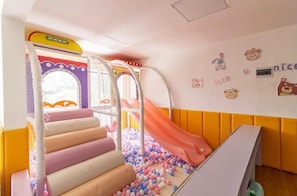 A children's play area with a slide, padded steps, and a ball pit. - Cozy 1BR in Kilimani - Epic Balcony & City Views (Nairobi)