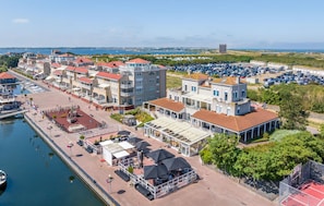Un hôtel situé sur la côte, composé de plusieurs bâtiments, doté d’un port de plaisance et d’un parking.