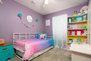 Une chambre à coucher comprenant un lit, une table de chevet, une bibliothèque et un élément de décoration murale.