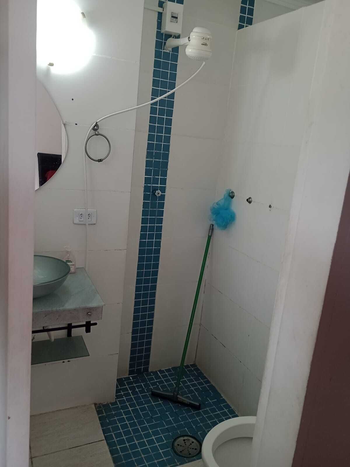 A small bathroom with a shower, a sink, and a toilet.