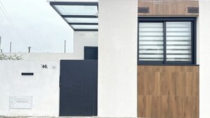 A modern building with a black door, a window with horizontal blinds, and a number '46' on the wall. - Espinho Beach House by Trip2Portugal (Espinho)
