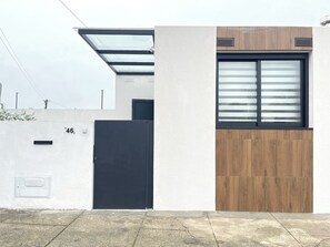 A modern building with a black door, a window with horizontal blinds, and a number '46' on the wall. - Espinho Beach House by Trip2Portugal (Espinho)