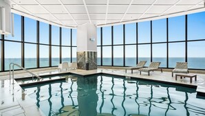 An indoor swimming pool with clear views of the ocean through large windows. - Level 42 Beachside 1BR Apartment with Ocean Views (Surfers Paradise)
