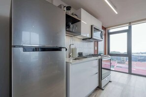 Eine moderne Küche mit Edelstahlgeräten, einem großen Fenster und Blick auf die Stadt.