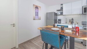 A compact kitchen with white cabinets, a wooden countertop, and a blue chair. - Apartment Upper Level in Casco View (Panamá)