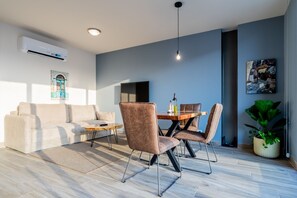 Una sala moderna con sofá, mesa de centro, mesa de comedor y sillas.