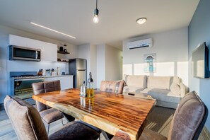 Una cocina moderna con comedor, que incluye una mesa de madera y sillas de cuero.