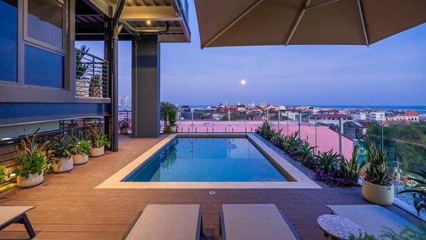 An outdoor swimming pool with a view of the cityscape and the sea. - Apartment Lower Level (Panama City)