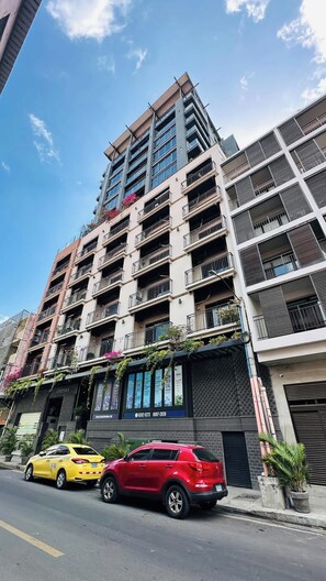 A multi-story building with balconies, a storefront, and parked cars. - Two-Level Penthouse | Bay & Cerro Ancón Views (Panama City)