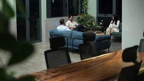 A modern lounge area with a blue sofa, a wooden table, and a potted plant. - Two-Level Penthouse | Bay & Cerro Ancón Views (Panama City)