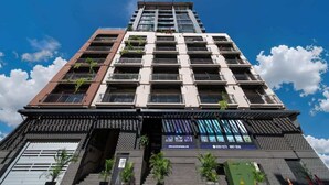 A multi-story building with balconies, a staircase, and a website banner. - Two-Level Penthouse | Bay & Cerro Ancón Views (Panama City)