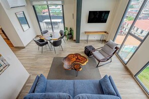Ein modernes Wohnzimmer mit Sofa, Couchtisch und Essbereich.
