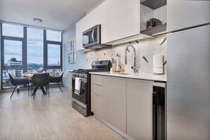 A modern kitchen with a built-in oven, microwave, and stainless steel refrigerator. - Penthouse with dual balconies and city views (Panama City)