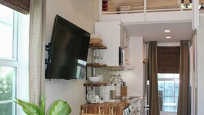 A compact living space with a dining area, kitchen, and a balcony. - Lighthouse Suites Collection (Key West)