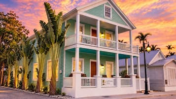 Une maison à deux étages dotée d’un balcon, d’une véranda et d’une enseigne indiquant qu’elle fait partie du complexe Lighthouse Suites.
