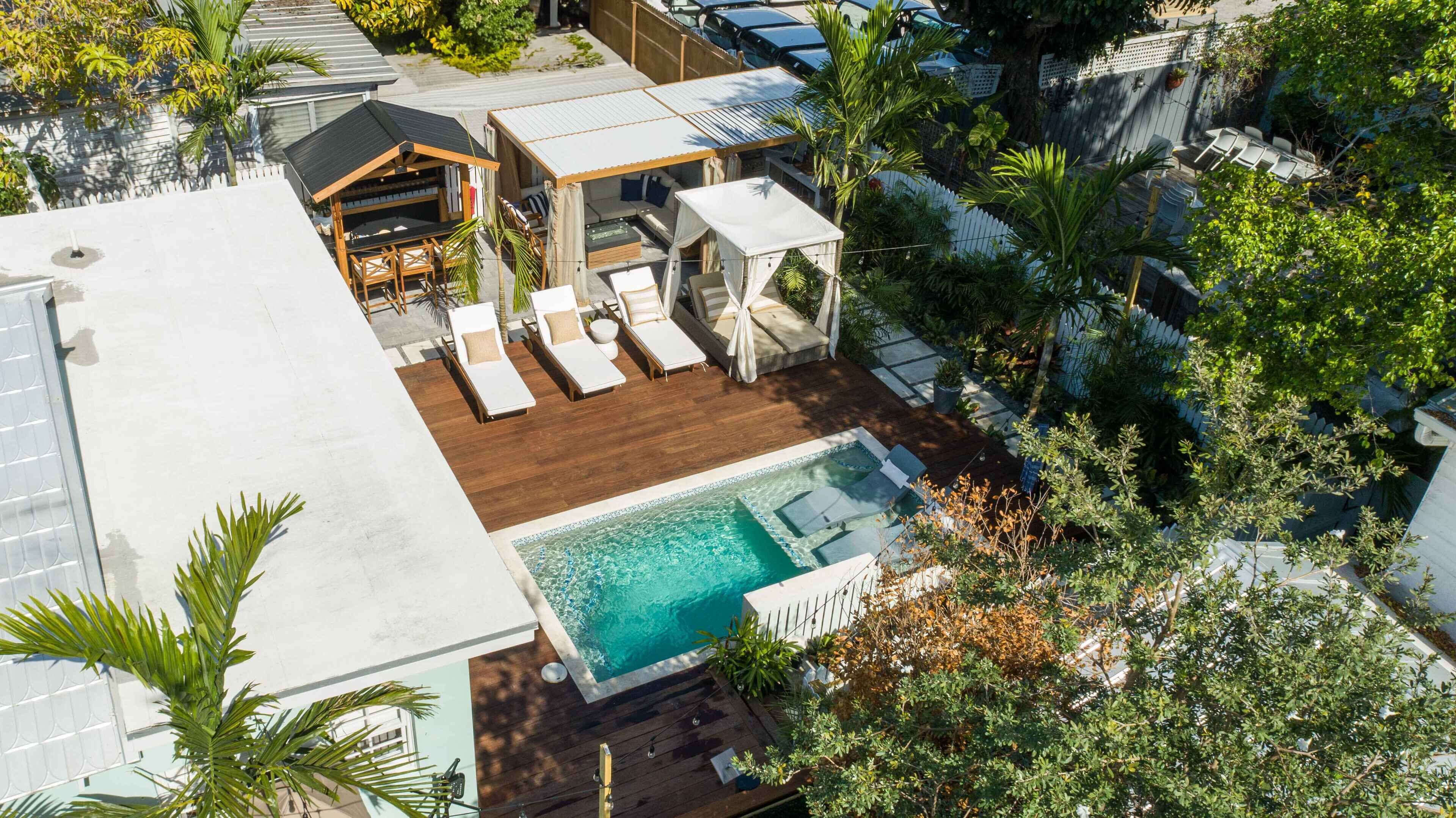 A rooftop pool area with lounge chairs, a small deck, and a covered seating area.