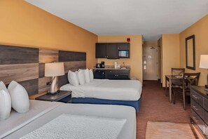 A hotel room with two beds, a kitchenette, a desk, and a chair. - Landmark 1006 (Myrtle Beach)