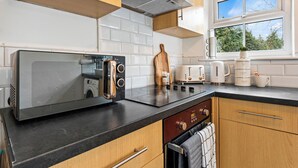 Una cocina moderna con microondas, tostadora y cafetera integrados.