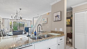 A kitchen with granite countertops, a stainless steel sink, and a chandelier. - PRIVATE BEACH - Two Bikes - Newly renovated - 7 Palms 3 (Panama City Beach)