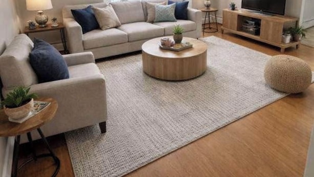 En moderne stue med en beige sofa, et rundt sofabord og et tv-møbel.