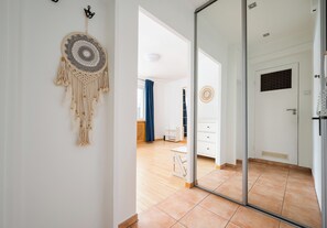 Un interior moderno con un vidrio que da a una habitación con un armario blanco y una pequeña mesa.