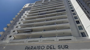 Ein Hochhaus mit mehreren Balkonen und der Aufschrift "PARAISO DEL SUR" an der Fassade.