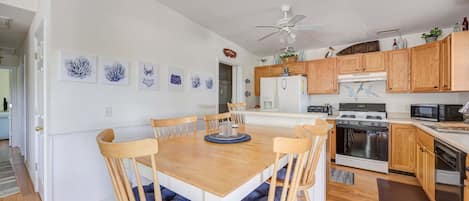 A kitchen with wooden cabinets, a white refrigerator, a stove, and a microwave.