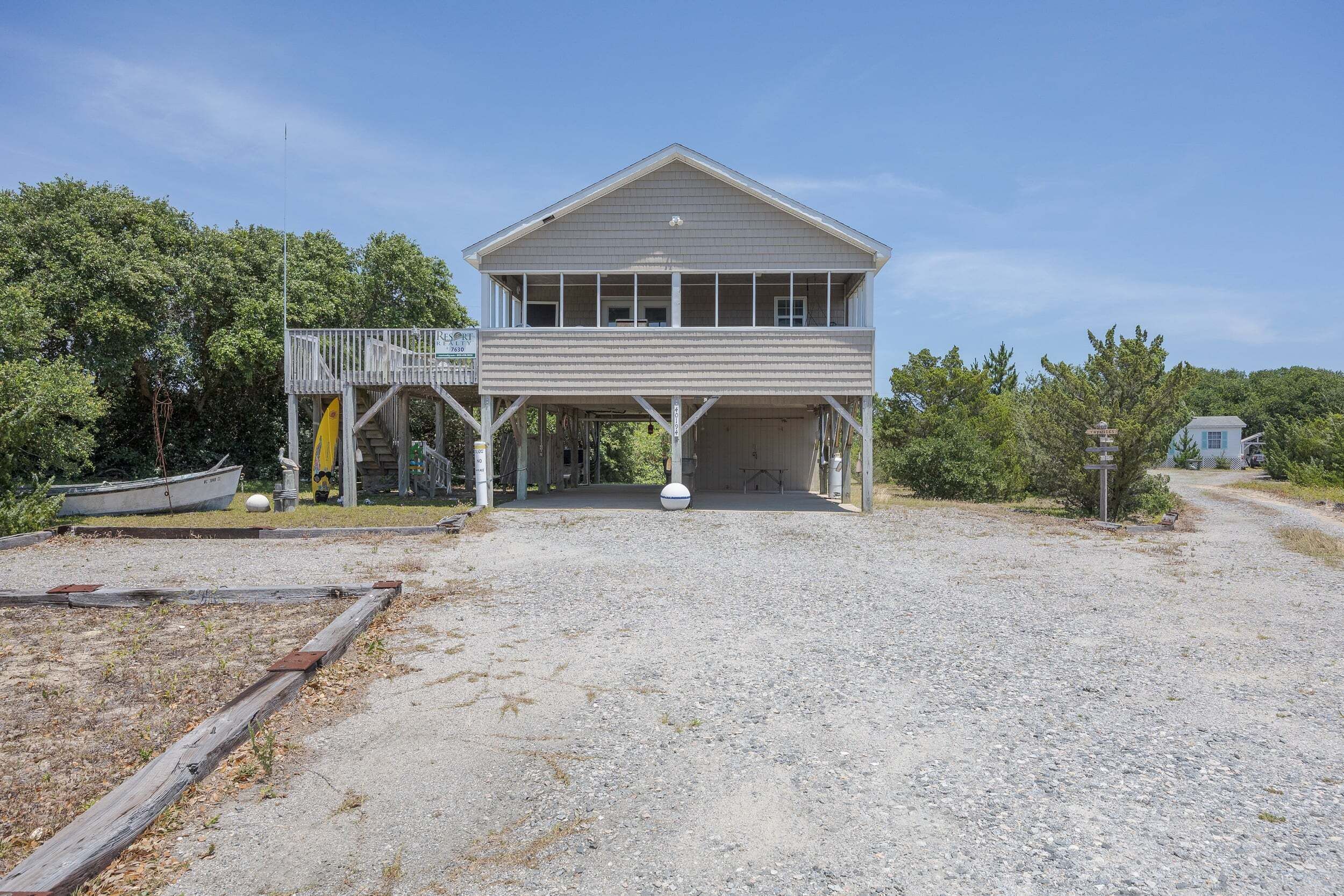 A two-story building with a covered porch and a small boat dock.