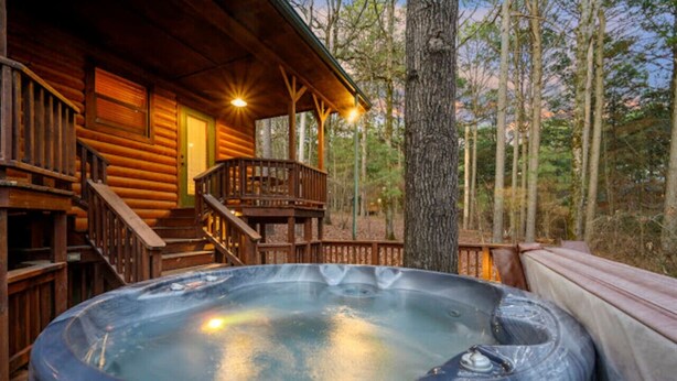 Ein Whirlpool auf einer Holzterrasse, im Hintergrund eine Holzhütte.