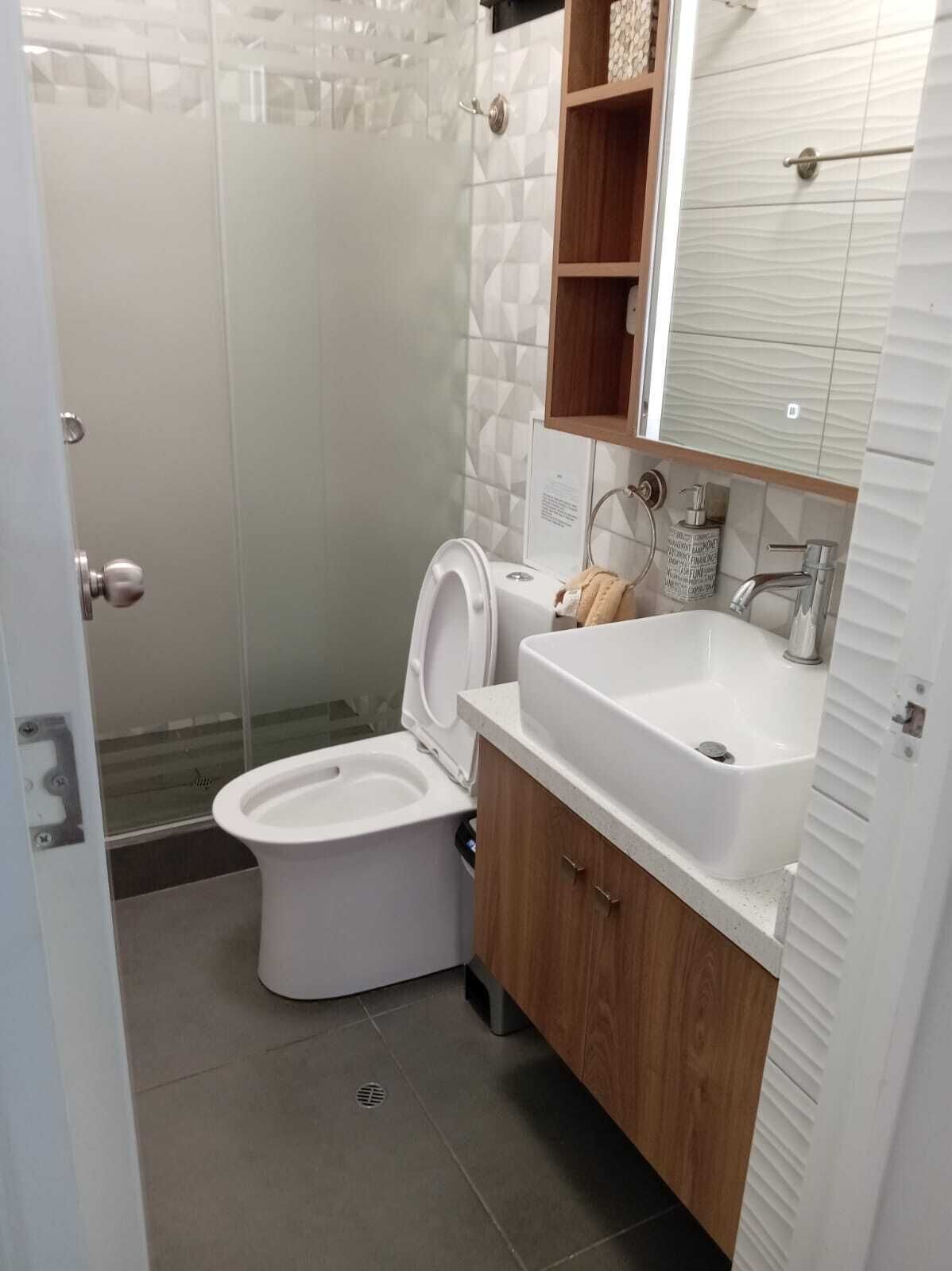 Un baño moderno con inodoro, lavabo y ducha.