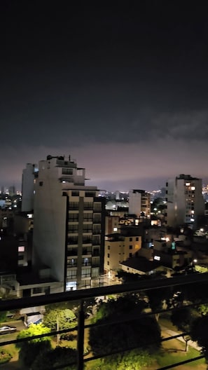 A nighttime cityscape with modern buildings and a view of the city below.