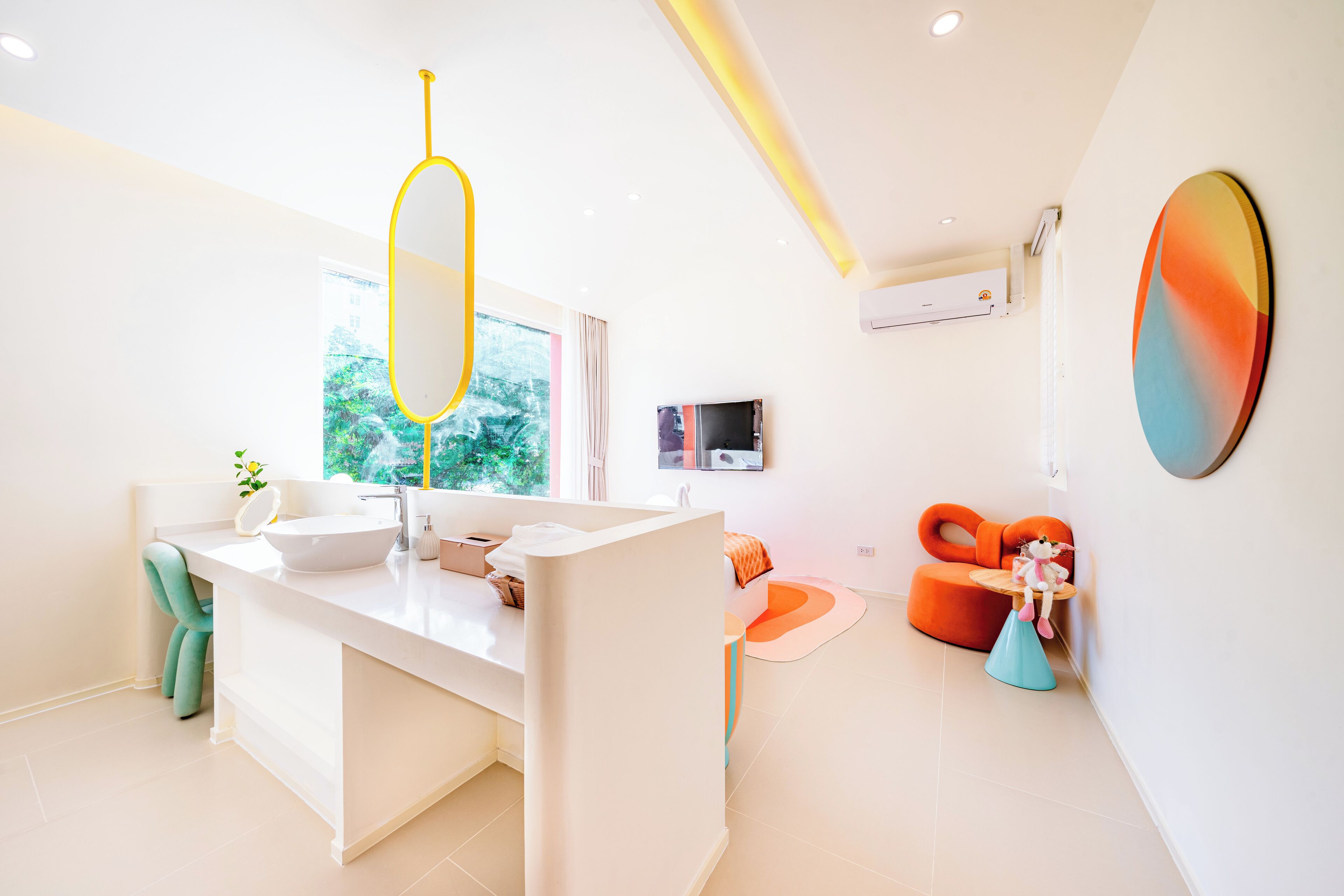Un bagno moderno con un mobile lavabo bianco, un'ampia finestra e vista sul verde.