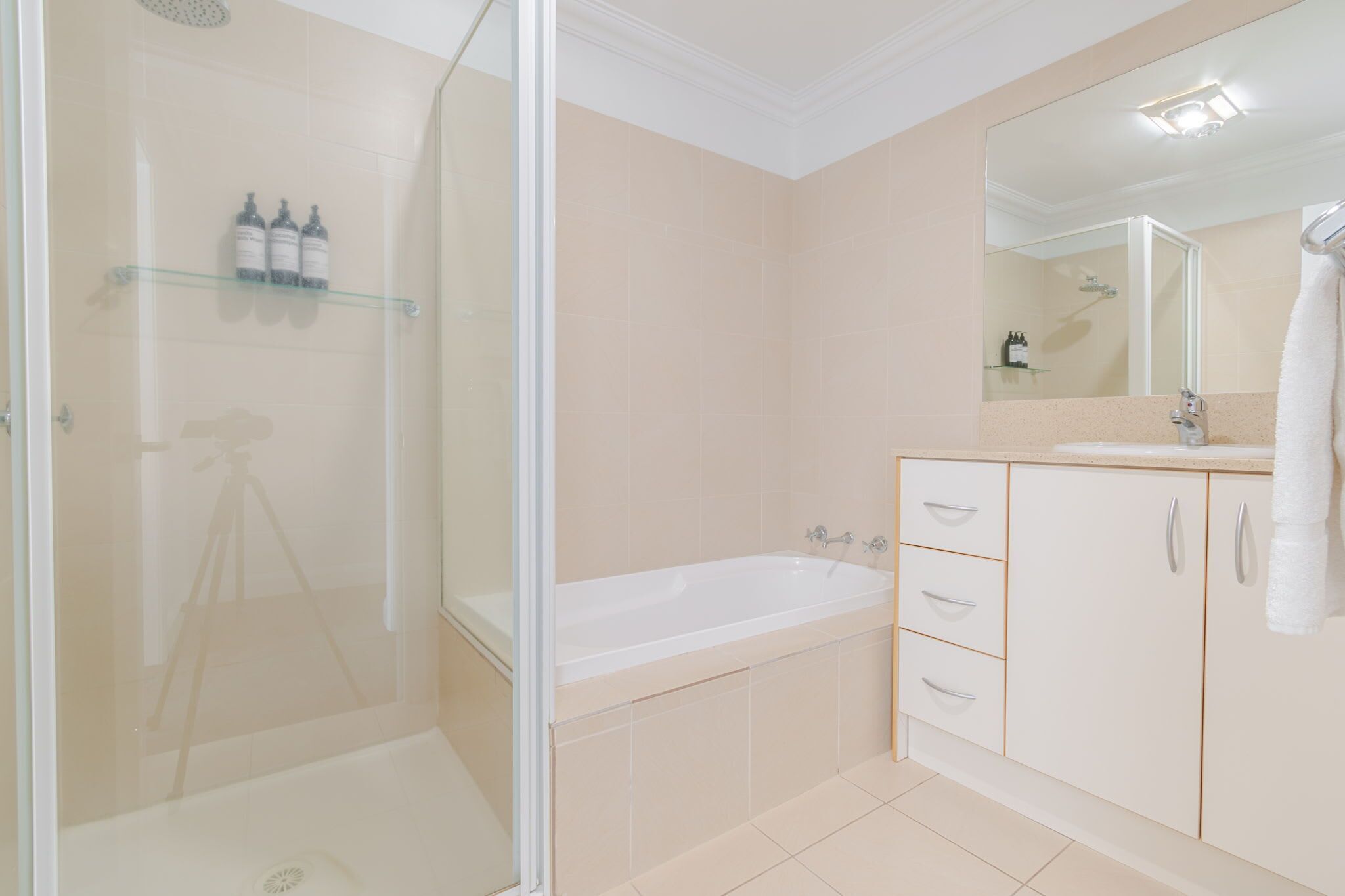 A modern bathroom with a glass-enclosed shower, a freestanding bathtub, and a vanity with a mirror.