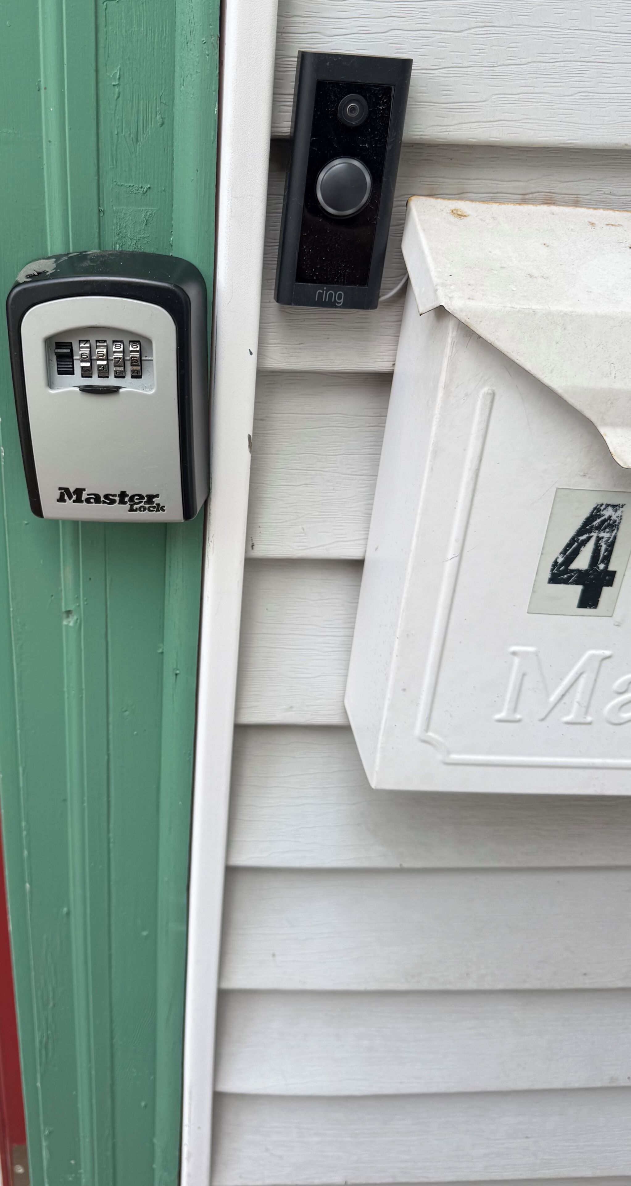 A door with a Master Lock device and a doorbell.