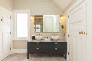 A bathroom with two sinks, a vanity, a large mirror, and a window. - Holme Station Homestead (Maungati)
