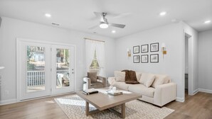 Un salon moderne avec un canapé blanc, une table basse et un ventilateur de plafond.