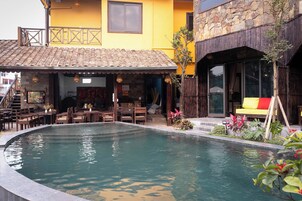 Una piscina al aire libre, sillones reclinables de piscina