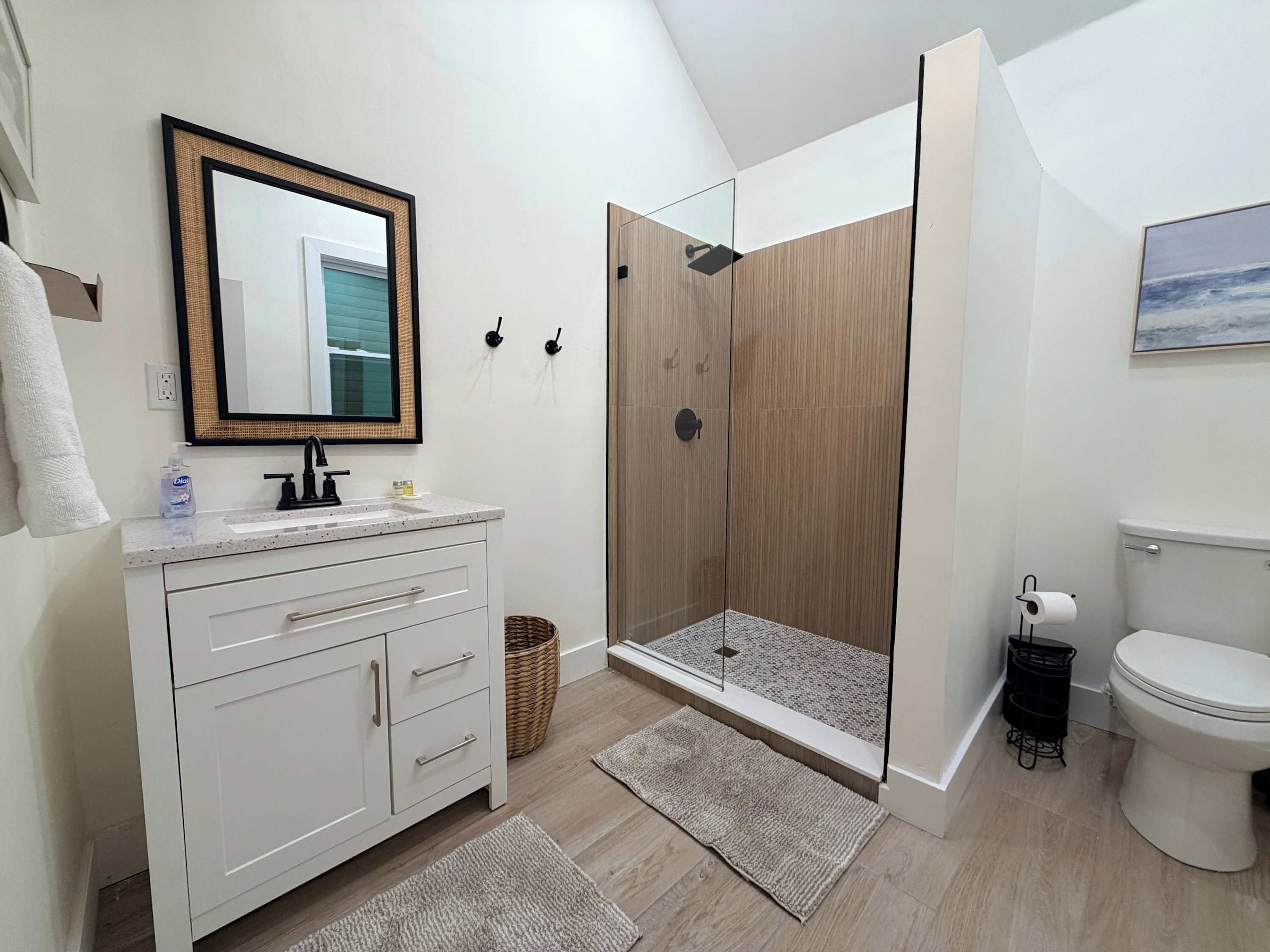 Un baño moderno con ducha, inodoro y tocador.