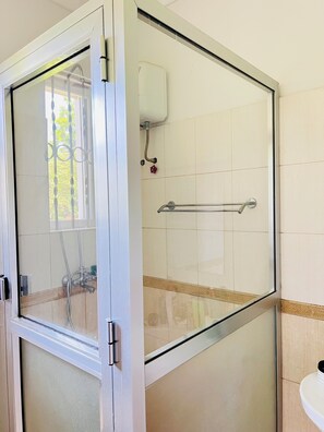 Een douche, handdoeken, zeep, toiletpapier