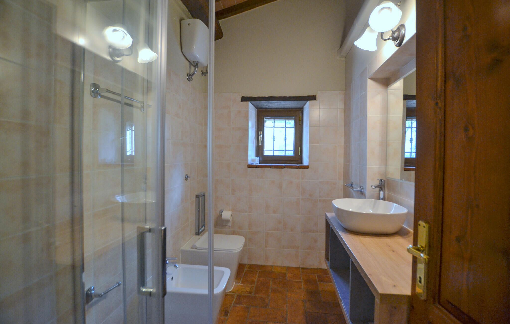 Ein Badezimmer mit Duschkabine aus Glas, Toilette, Badewanne und großem Waschbecken mit Spiegel.