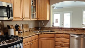 A kitchen with wooden cabinets, a stainless steel stove, a sink, and a dishwasher. - Fire Horse Ranch Desert Hot Springs Ca (Desert Hot Springs)