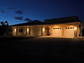 Ein zweistöckiges Haus mit Garage, überdachter Veranda und einer Treppe zum zweiten Stockwerk.