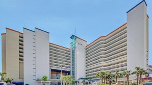 Ein modernes Hotel mit mehreren Etagen, einem zentralen Turm und einer Tiefgarage.