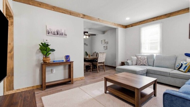 A living room with a sofa, coffee table, and a dining area with chairs and a table. - Farmhouse less than a mile from beaches (Millcreek Township)